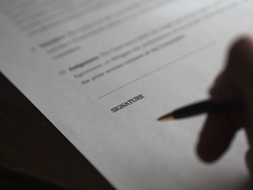 Signature d'un contrat de réservation, symbole de l'engagement entre le camping et le client