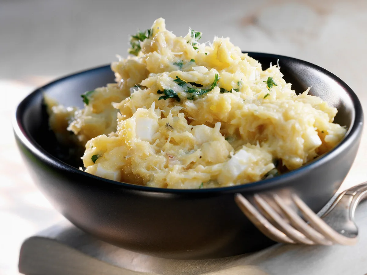 Estofinado dans un bol, purée de morue et pommes de terre parsemée de persil et d'œufs durs