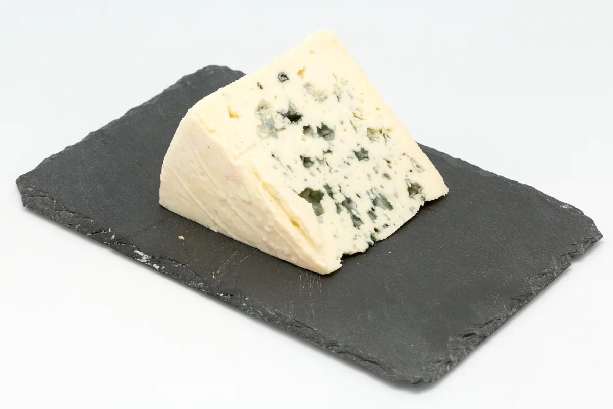 Meule de Bleu des Causses AOP coupée en deux, montrant le persillage bleu-vert caractéristique de la pâte