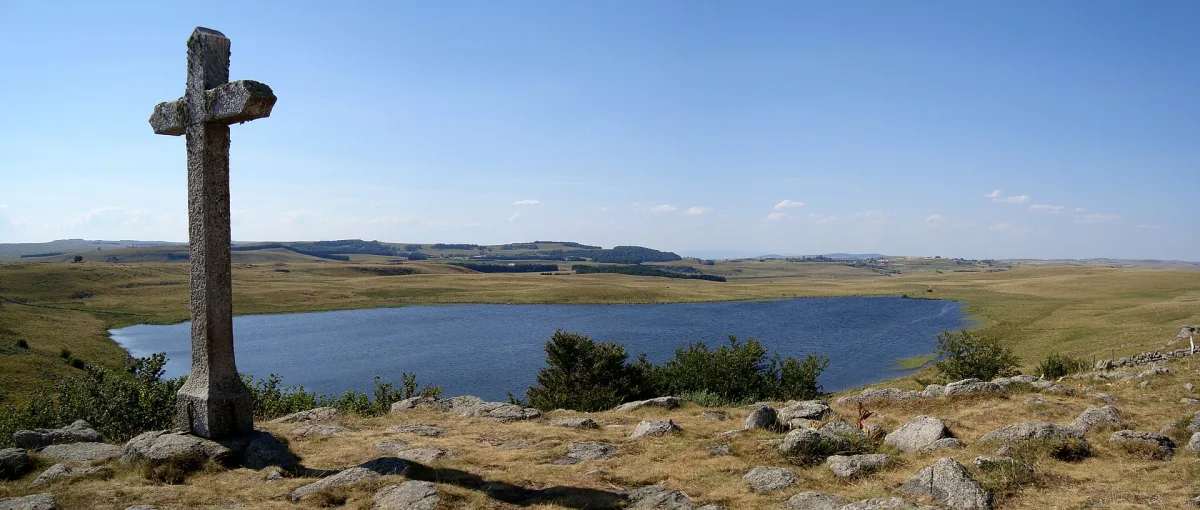 Le lac de Saint-Andéol sur le plateau de l'Aubrac, étendue d'eau calme entourée de pâturages et de tourbières