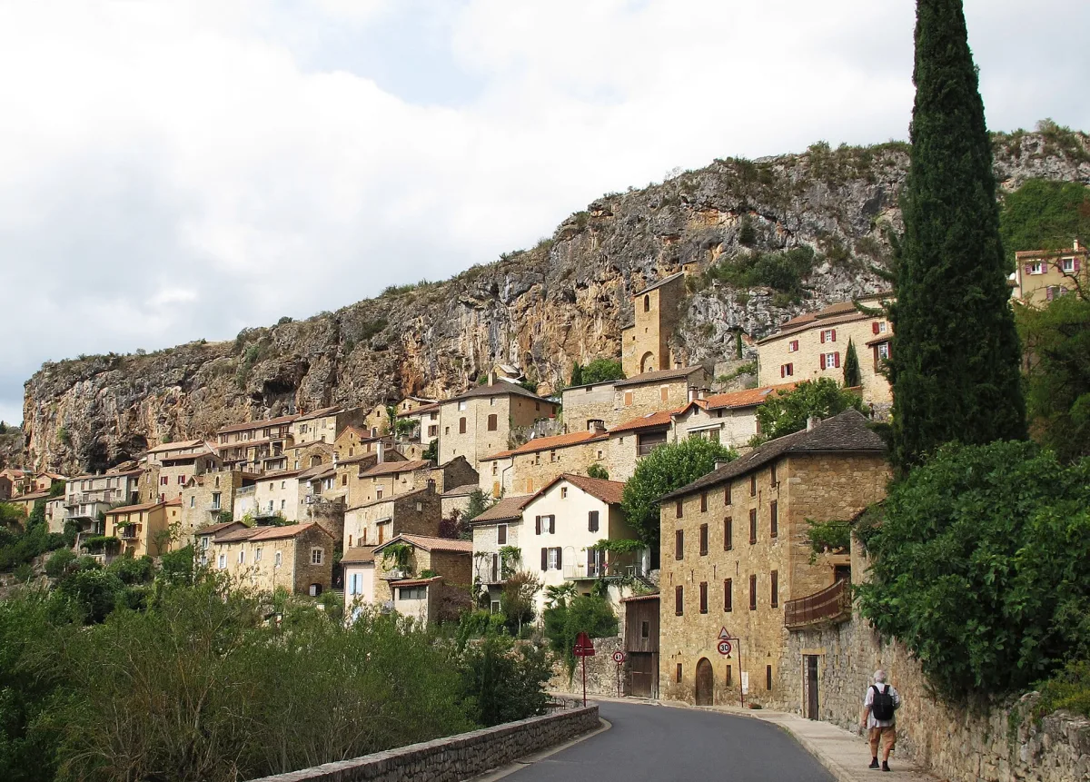 Maisons troglodytiques en pierre et lauze de Peyre adossées à la falaise calcaire au bord du Tarn